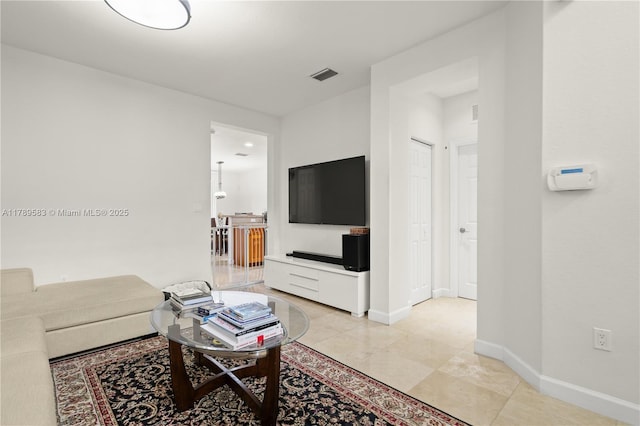 living area featuring light tile patterned flooring, visible vents, and baseboards