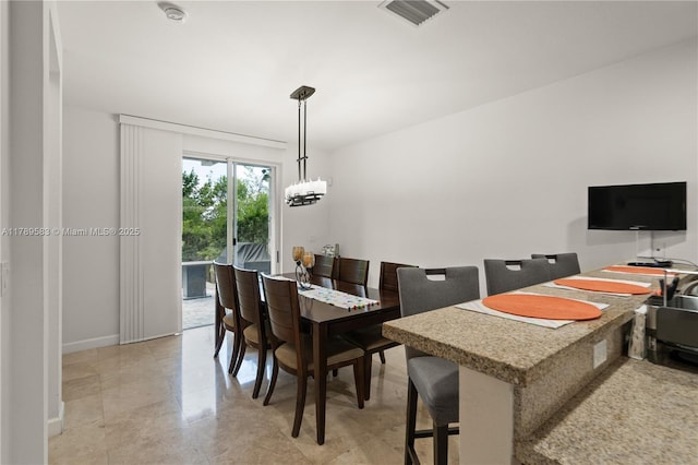 dining room with a notable chandelier, visible vents, and baseboards