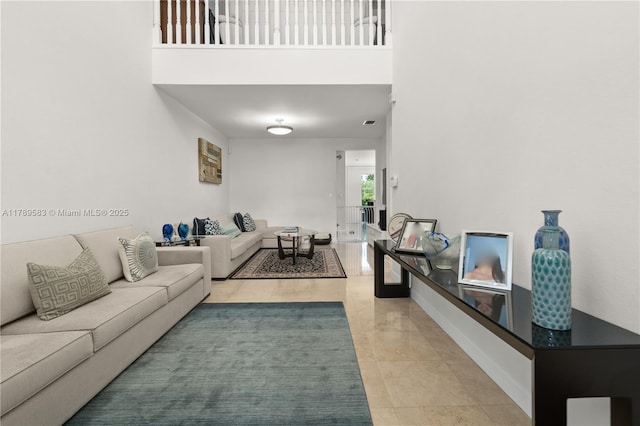 living area with light tile patterned flooring and a high ceiling