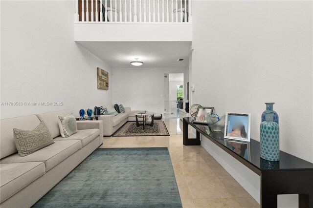 living area featuring light tile patterned flooring and a high ceiling