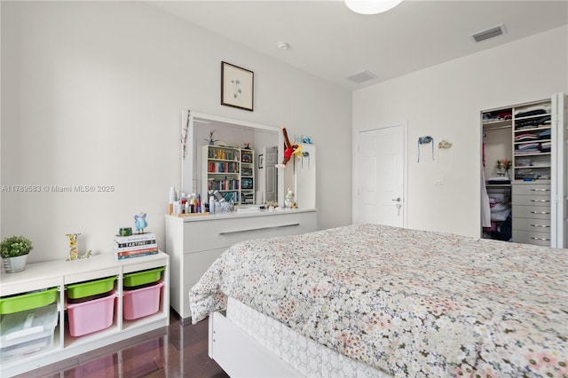 bedroom with visible vents, dark wood-style flooring, and a closet