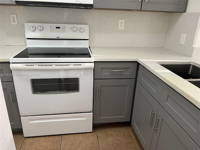 7985 NW 8th St Unit 110A, Miami, FL 33126 - kitchen featuring white electric stove, gray cabinetry, tile patterned floors, light countertops, and range hood