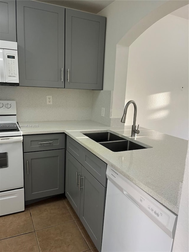 7985 NW 8th St Unit 110A, Miami, FL 33126 - kitchen with white appliances, gray cabinetry, a sink, a peninsula, and tile patterned floors