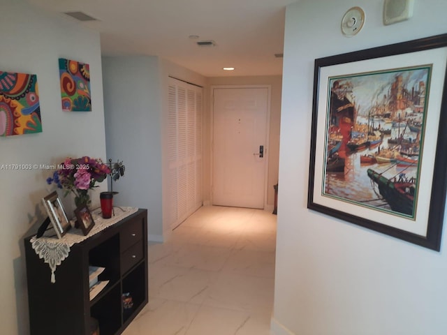 hallway featuring baseboards, visible vents, recessed lighting, and marble finish floor
