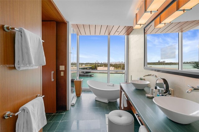 10295 Collins Ave Unit 312, Bal Harbour, FL 33154 - full bathroom with a freestanding bath, tile patterned flooring, double vanity, and a sink
