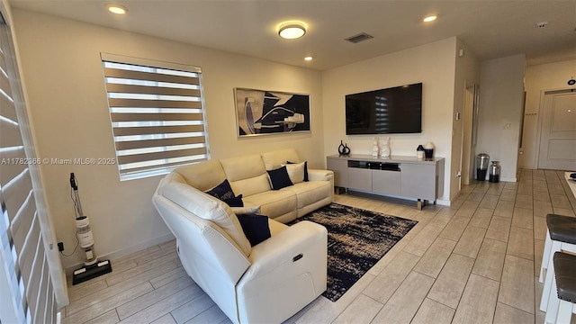 living area with baseboards, visible vents, and light wood finished floors