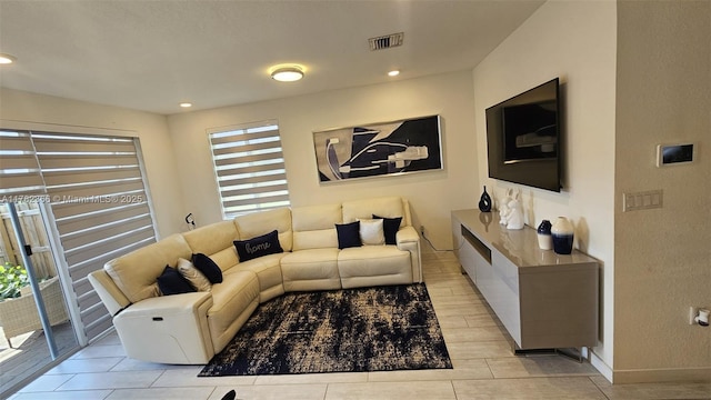 living room featuring baseboards, visible vents, and recessed lighting