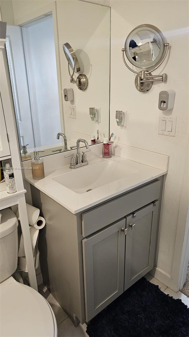 bathroom featuring toilet, vanity, and tile patterned flooring