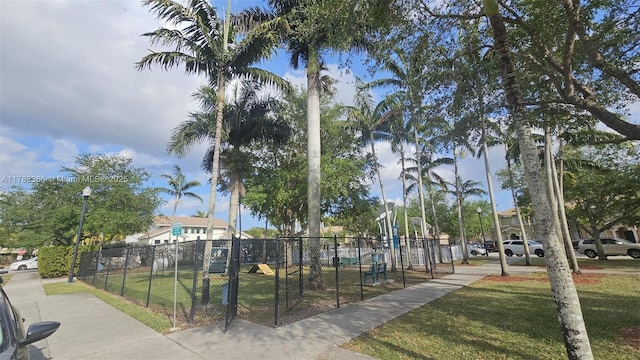 view of home's community featuring a lawn and fence