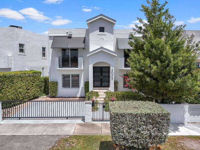 3025 SW 13th St, Miami, FL 33145 - view of front of house with a fenced front yard, stucco siding, and french doors