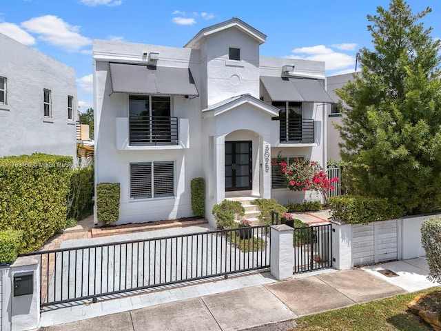 3025 SW 13th St, Miami, FL 33145 - view of front facade with a fenced front yard, stucco siding, french doors, and a balcony