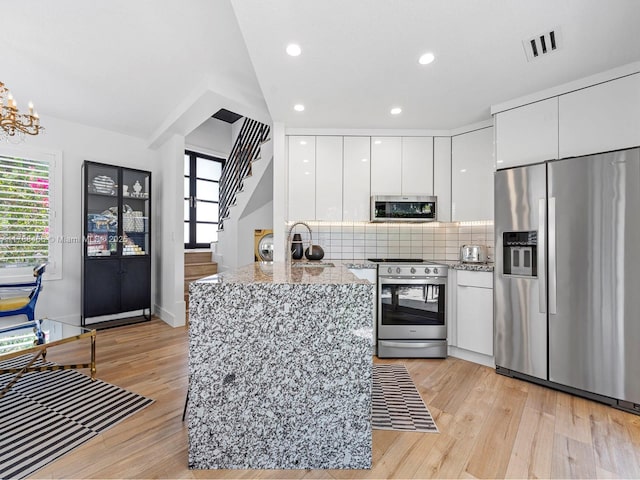 3025 SW 13th St, Miami, FL 33145 - kitchen with appliances with stainless steel finishes, modern cabinets, white cabinets, light wood-type flooring, and tasteful backsplash
