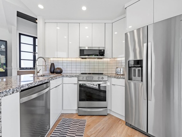 3025 SW 13th St, Miami, FL 33145 - kitchen with stainless steel appliances, modern cabinets, a sink, white cabinetry, and decorative backsplash