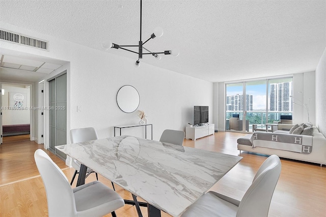 19390 Collins Ave Unit 1501, Sunny Isles Beach, FL 33160 - dining space with a textured ceiling, light wood finished floors, a chandelier, and a wall of windows