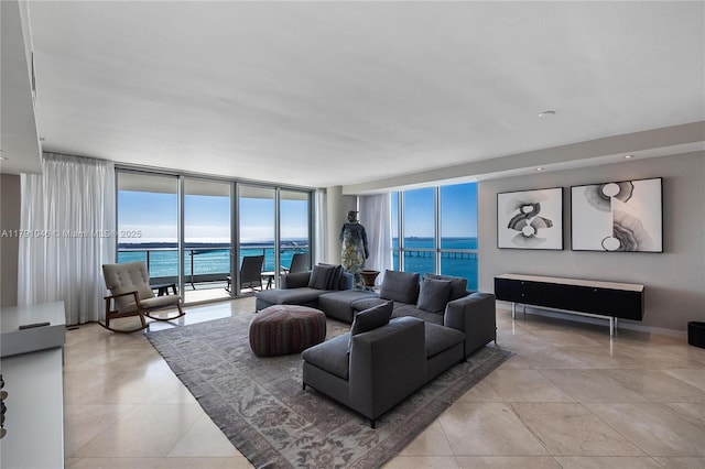 living room featuring light tile patterned floors, a healthy amount of sunlight, expansive windows, and a water view