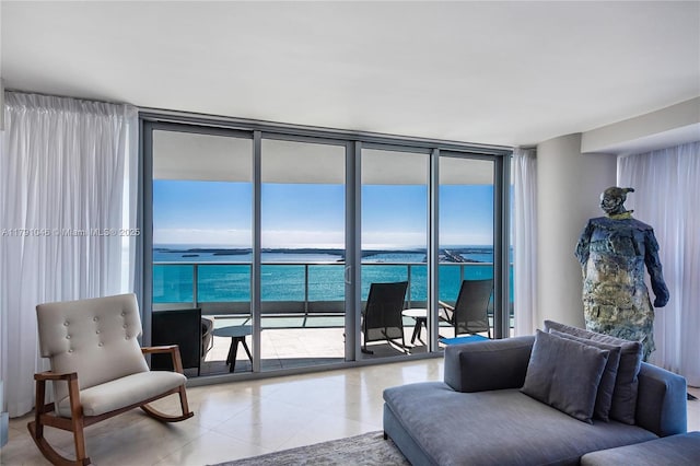 living room featuring light tile patterned floors, a water view, and expansive windows