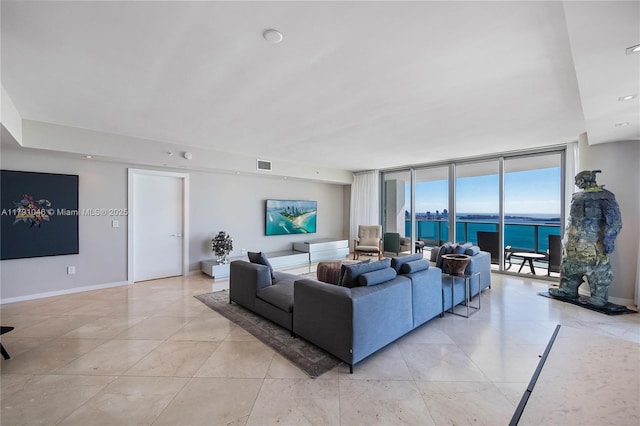 living room featuring visible vents, floor to ceiling windows, and baseboards