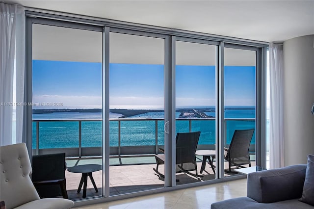 tiled living room with a wall of windows, a water view, and plenty of natural light
