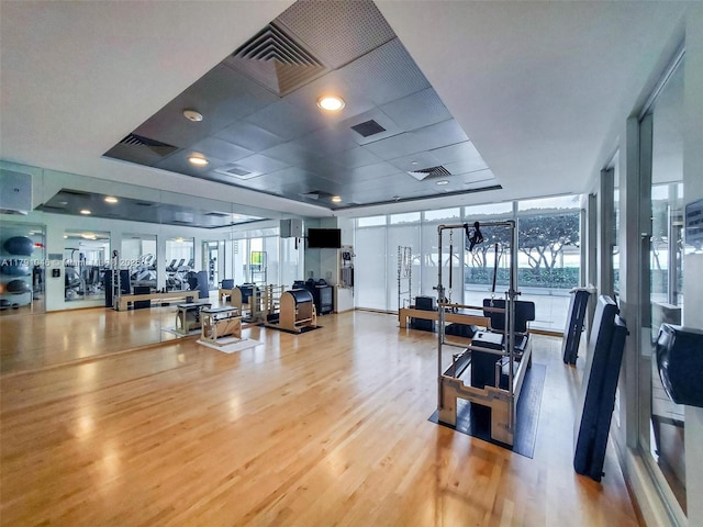 workout area with visible vents, wood finished floors, and french doors