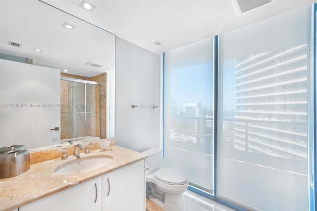 bathroom featuring visible vents, a stall shower, toilet, and vanity