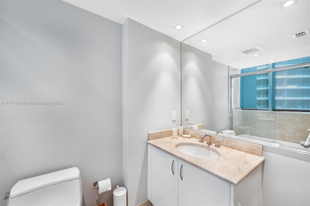 bathroom with recessed lighting, a shower stall, toilet, vanity, and visible vents
