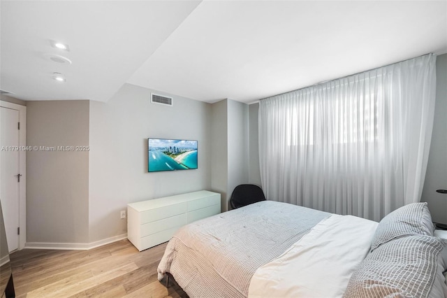 bedroom featuring baseboards, visible vents, light wood-style floors, and recessed lighting