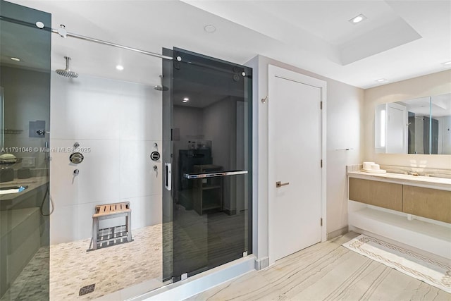 bathroom with a tile shower, recessed lighting, vanity, and baseboards