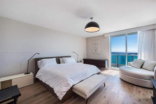 bedroom with wood finished floors and access to exterior