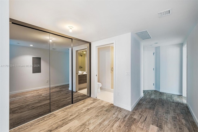 unfurnished bedroom with a closet, visible vents, and wood finished floors