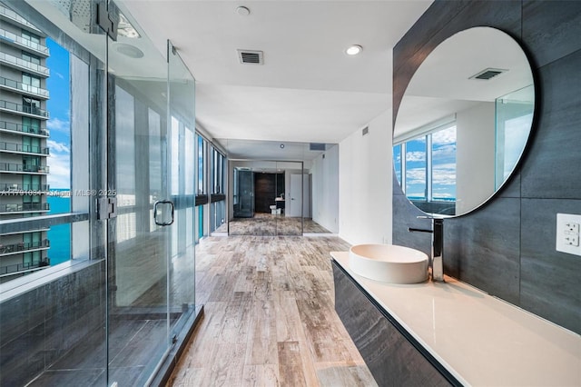 full bathroom featuring visible vents, wood finished floors, and a stall shower