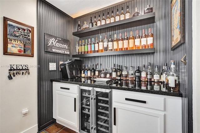 bar featuring baseboards, beverage cooler, and a dry bar