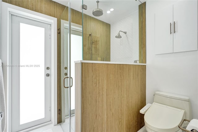 full bathroom with a shower with shower door, toilet, and plenty of natural light