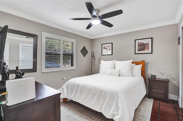 bedroom featuring dark tile patterned floors, baseboards, a ceiling fan, and crown molding
