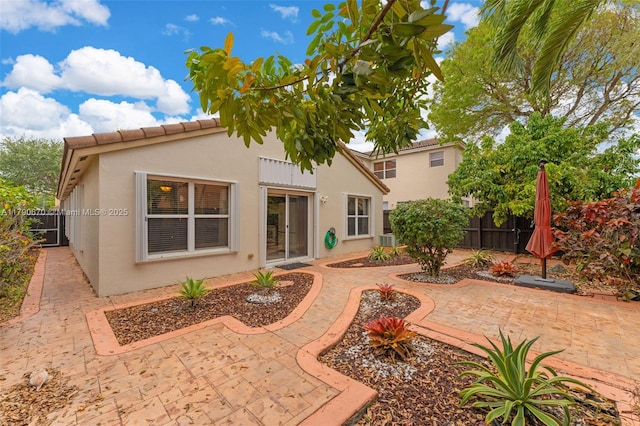 back of property featuring fence, a patio area, and stucco siding