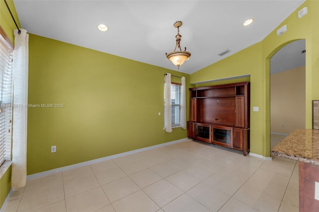 interior space with recessed lighting, visible vents, baseboards, arched walkways, and lofted ceiling