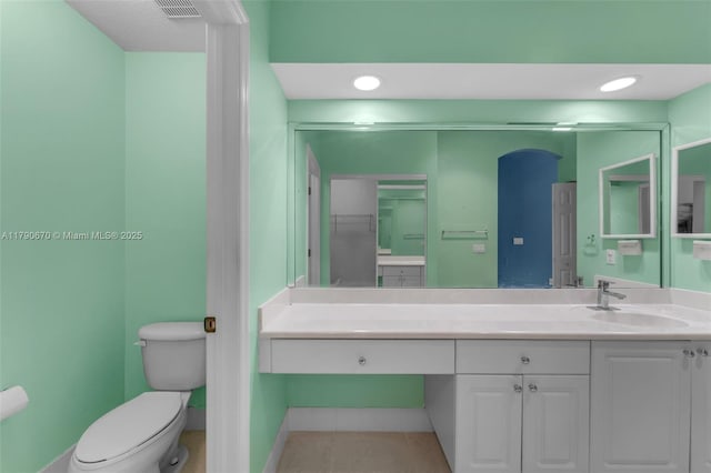 bathroom with vanity, toilet, visible vents, baseboards, and tile patterned flooring