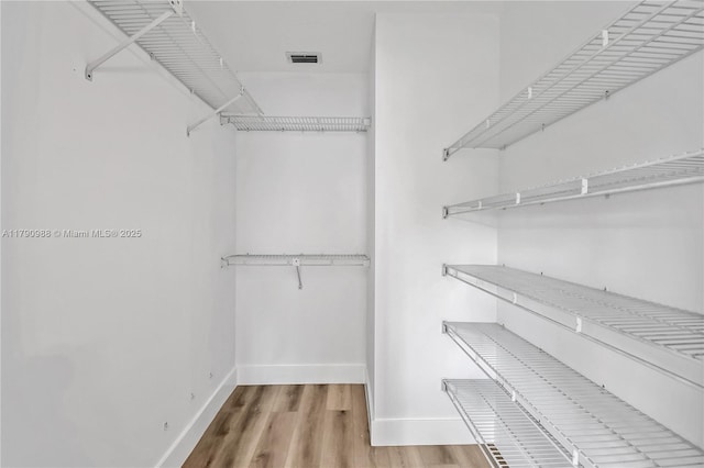 walk in closet featuring wood finished floors and visible vents