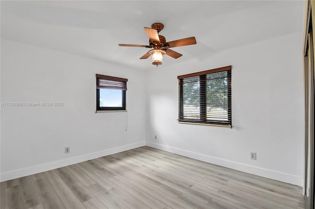 empty room with plenty of natural light, a ceiling fan, baseboards, and light wood finished floors