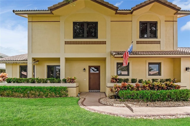 mediterranean / spanish house featuring stucco siding and a tile roof