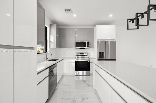 kitchen featuring recessed lighting, a sink, modern cabinets, visible vents, and appliances with stainless steel finishes