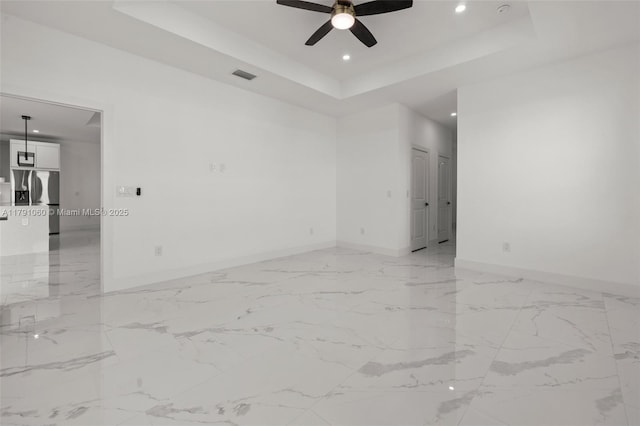 spare room featuring recessed lighting, a raised ceiling, a ceiling fan, visible vents, and baseboards