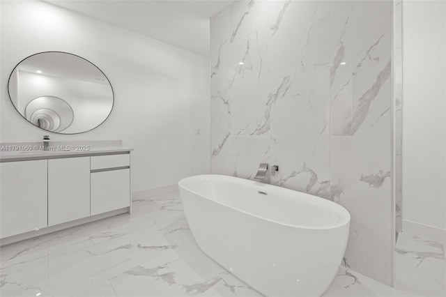 bathroom featuring baseboards, a freestanding tub, vanity, and marble finish floor
