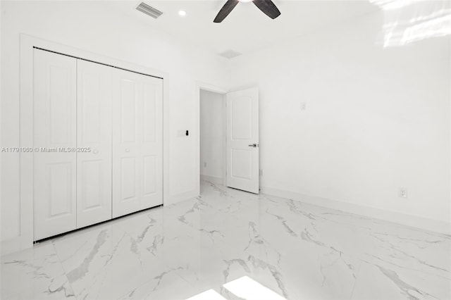 unfurnished bedroom featuring a closet, marble finish floor, ceiling fan, baseboards, and visible vents