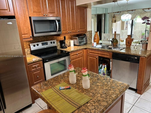 9040 SW 125th Ave Unit D105, Miami, FL 33186 - kitchen featuring brown cabinets, a peninsula, stainless steel appliances, and decorative backsplash