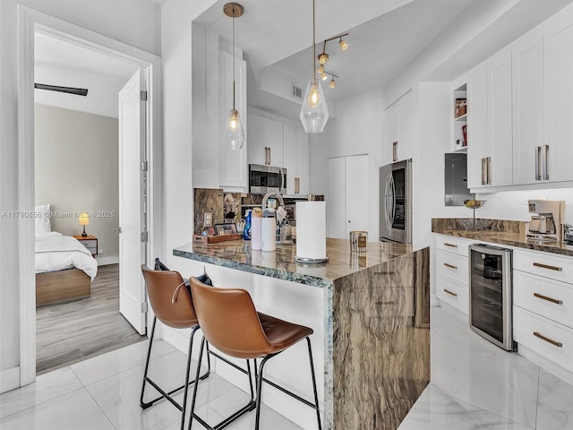 888 Brickell Key Dr Unit 2709, Miami, FL 33131 - kitchen featuring dark stone counters, white cabinets, stainless steel microwave, and wine cooler
