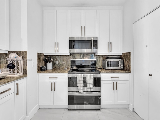888 Brickell Key Dr Unit 2709, Miami, FL 33131 - kitchen with dark stone counters, appliances with stainless steel finishes, decorative backsplash, and white cabinetry