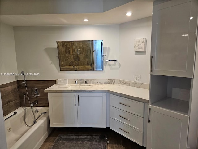 bathroom featuring recessed lighting, a bathing tub, vanity, wood finished floors, and a shower with door