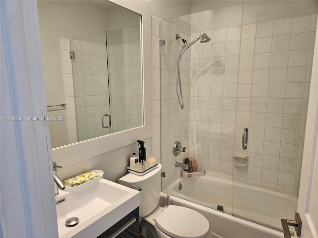 bathroom with bath / shower combo with glass door, vanity, and toilet
