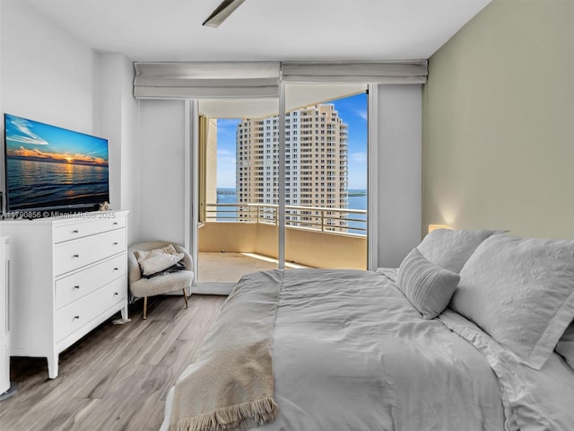 888 Brickell Key Dr Unit 2709, Miami, FL 33131 - bedroom with access to outside, wood finished floors, and a water view