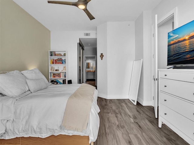 888 Brickell Key Dr Unit 2709, Miami, FL 33131 - bedroom with connected bathroom, a ceiling fan, baseboards, wood finished floors, and visible vents